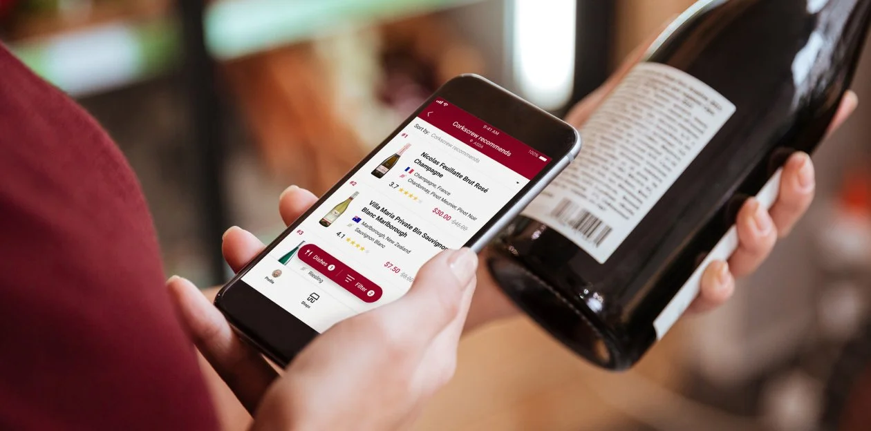 Person looking at a smartphone with a restaurant or wine list app open, showing options and ratings